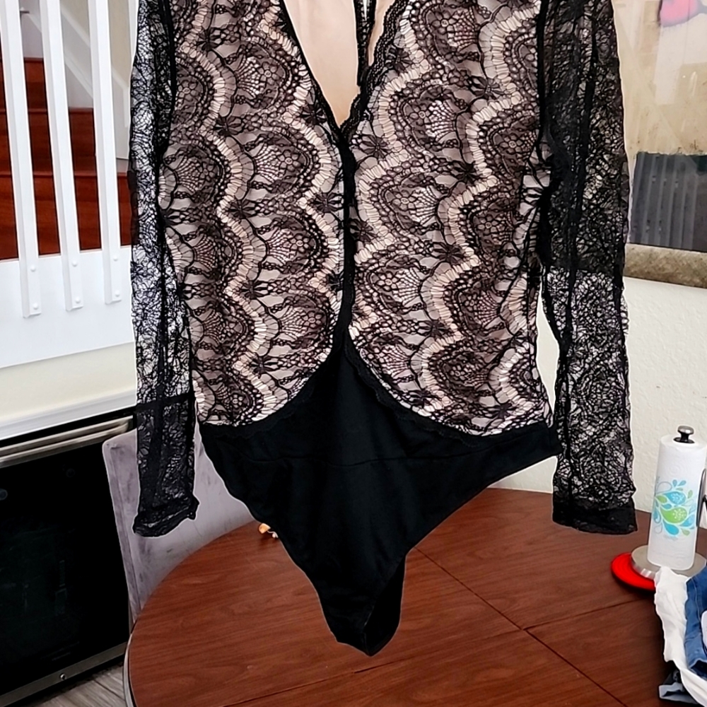 Lace black bodysuit, lined in cream, long sleeved. Snaps at crotch.